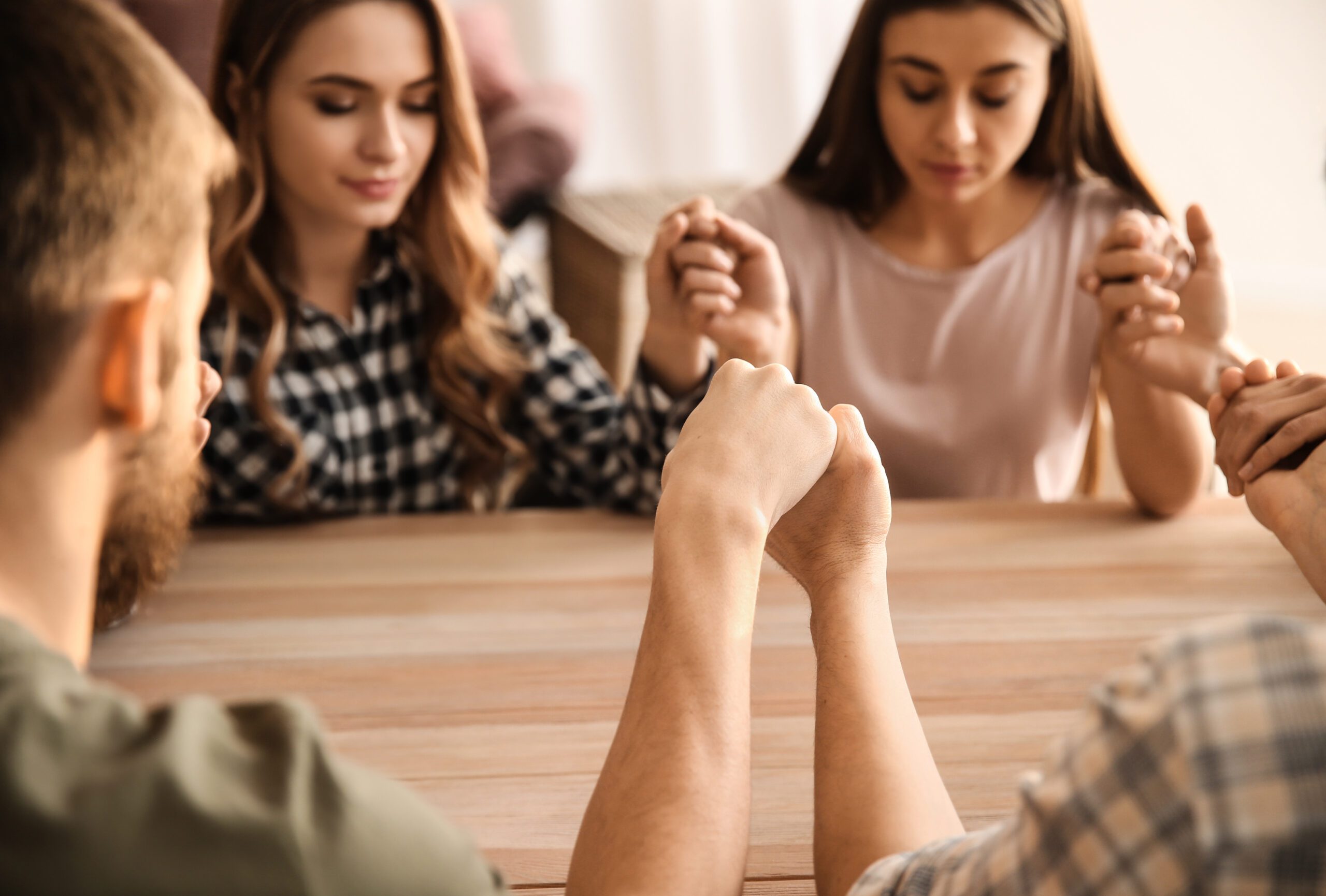 Group Of People Praying At Table